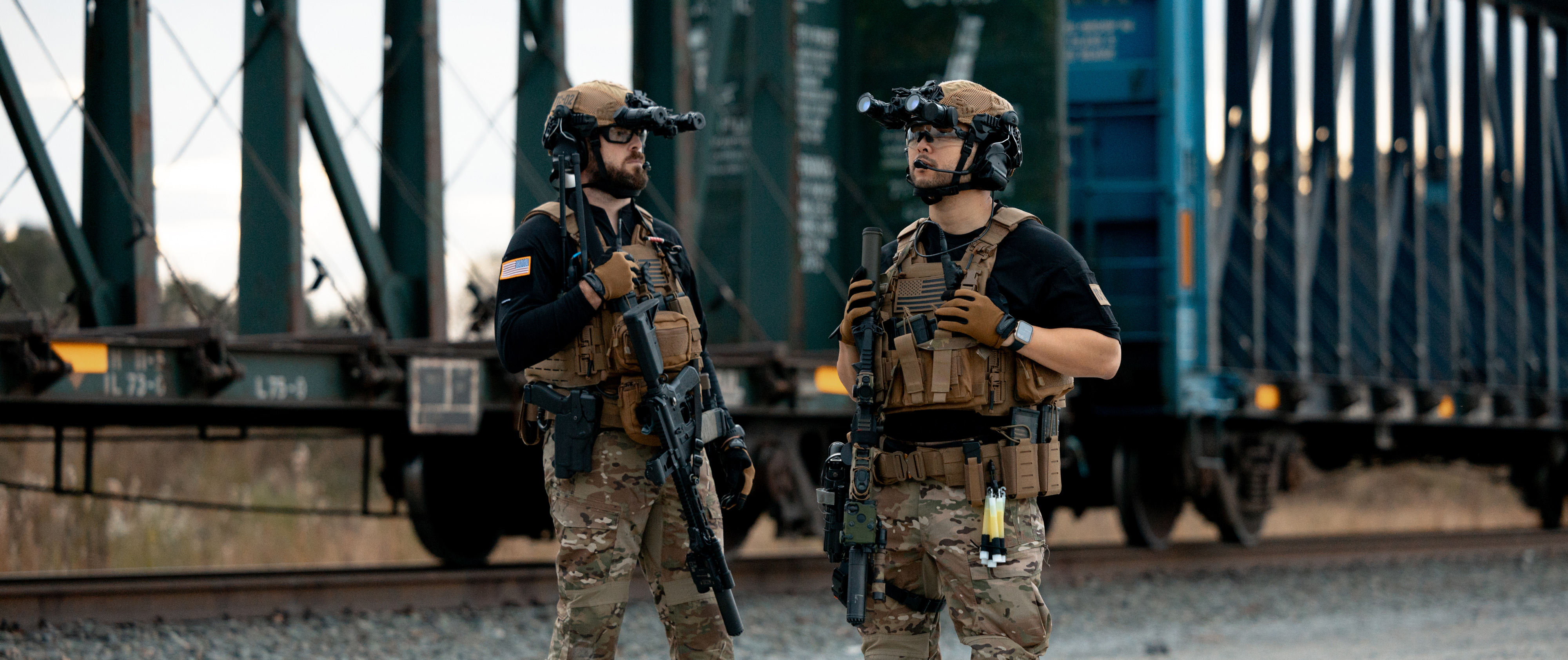 2 people shooting pistols in full kit and trident short sleeve shirts