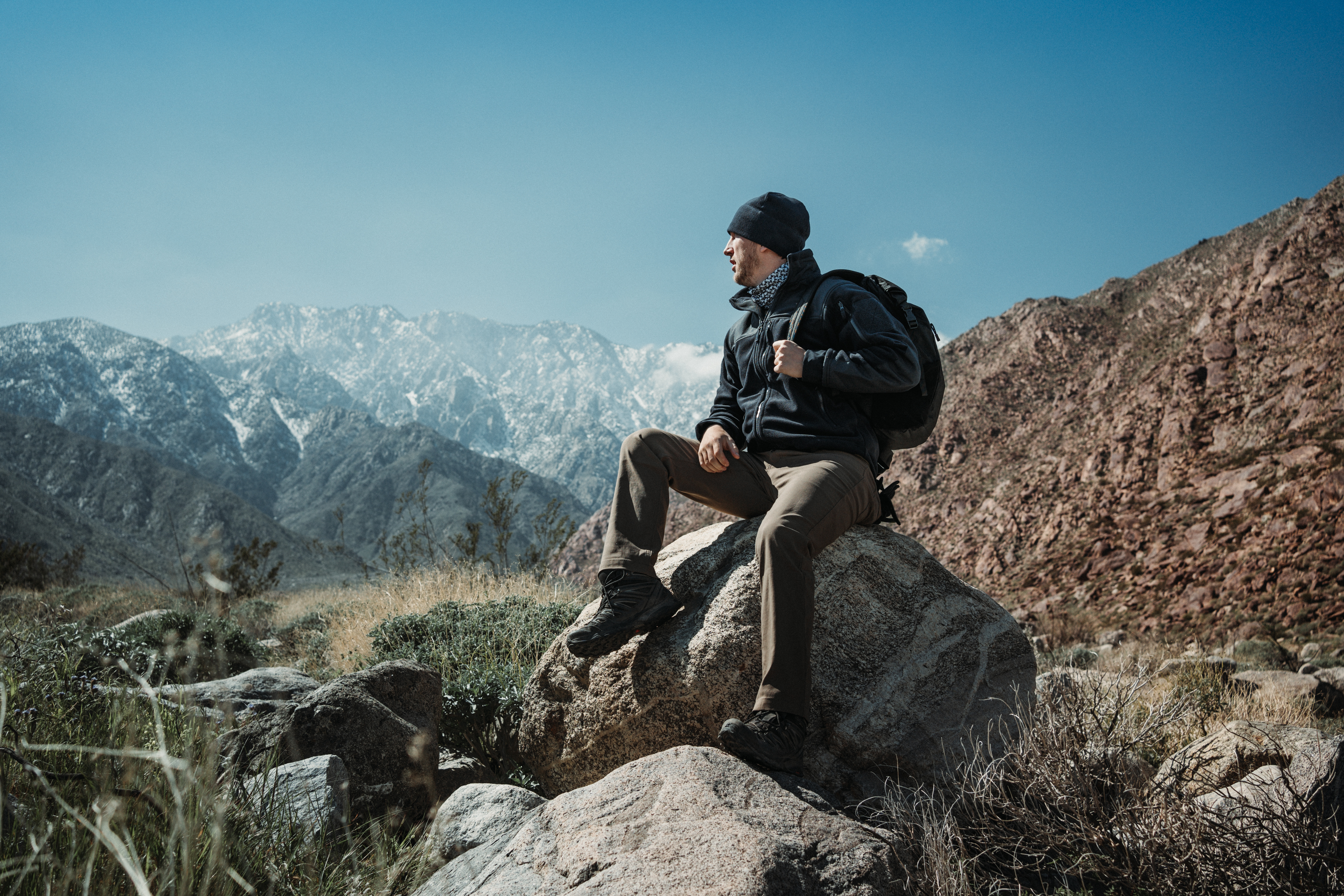 Image of a person with a snowy mountain in the background wearing a bravo fleece jacket