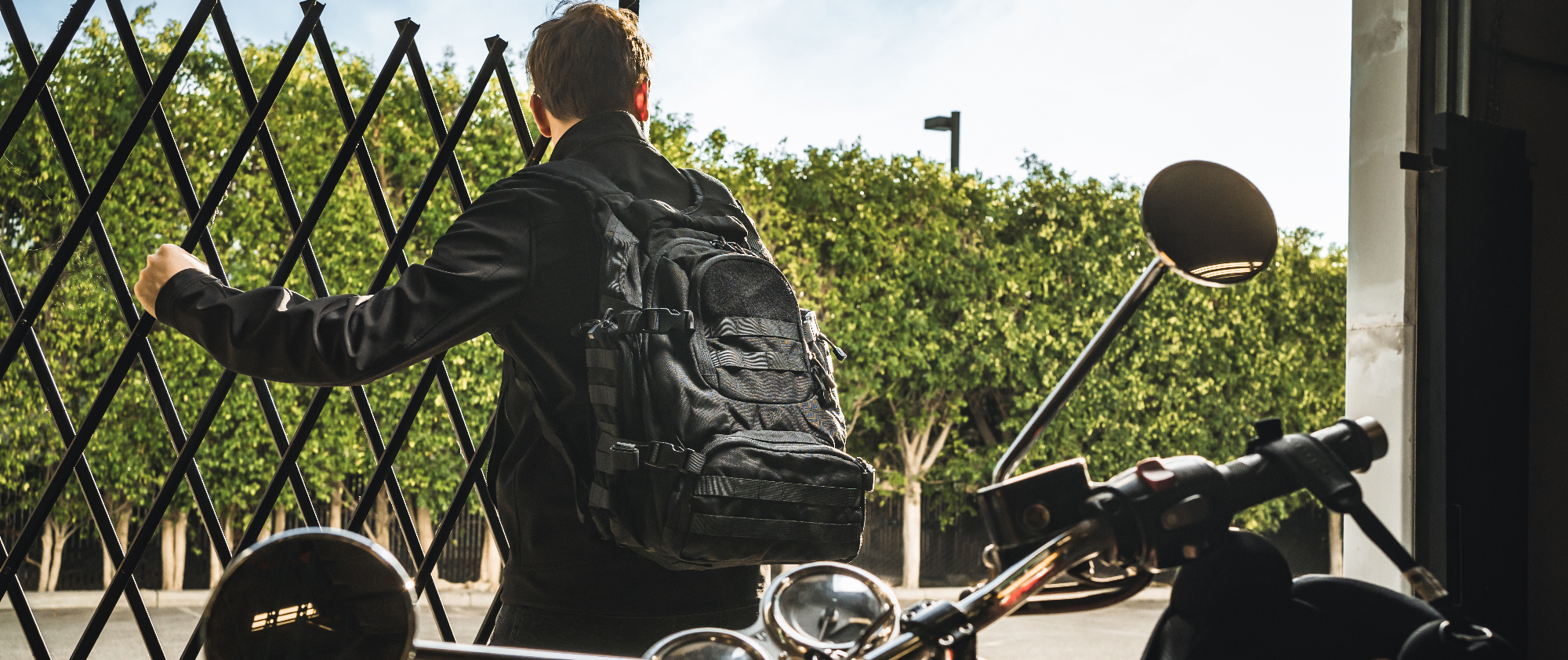 Image of someone opening a gate while wearing a backpack