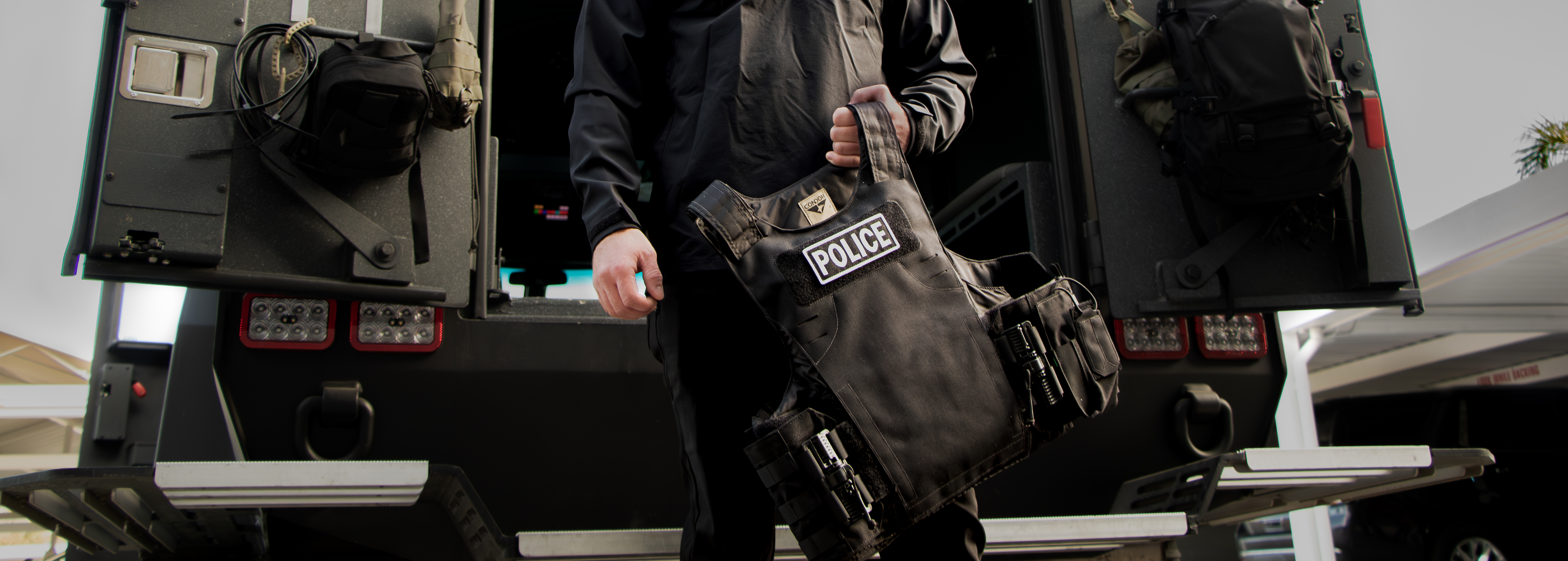 Image of a police officer holding this scalable plate carrier next to a bearcat
