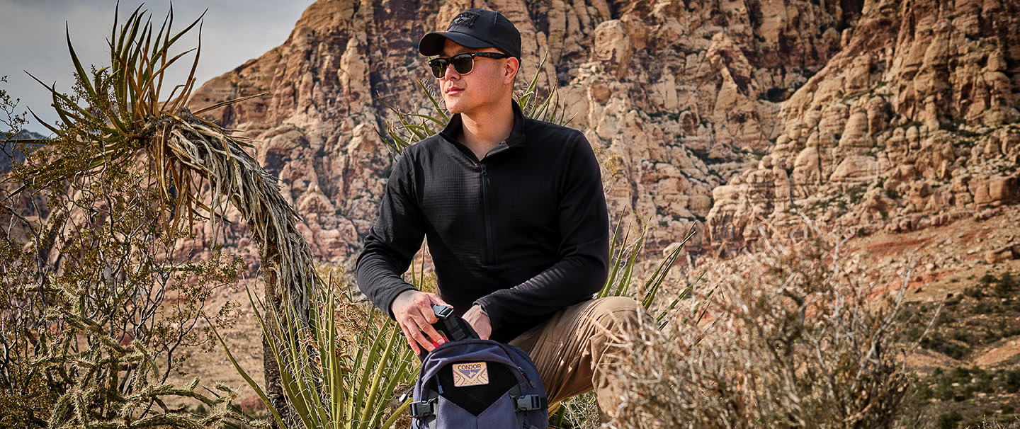 an image of a man kneeling in some canyons wearing a black base II waffle top