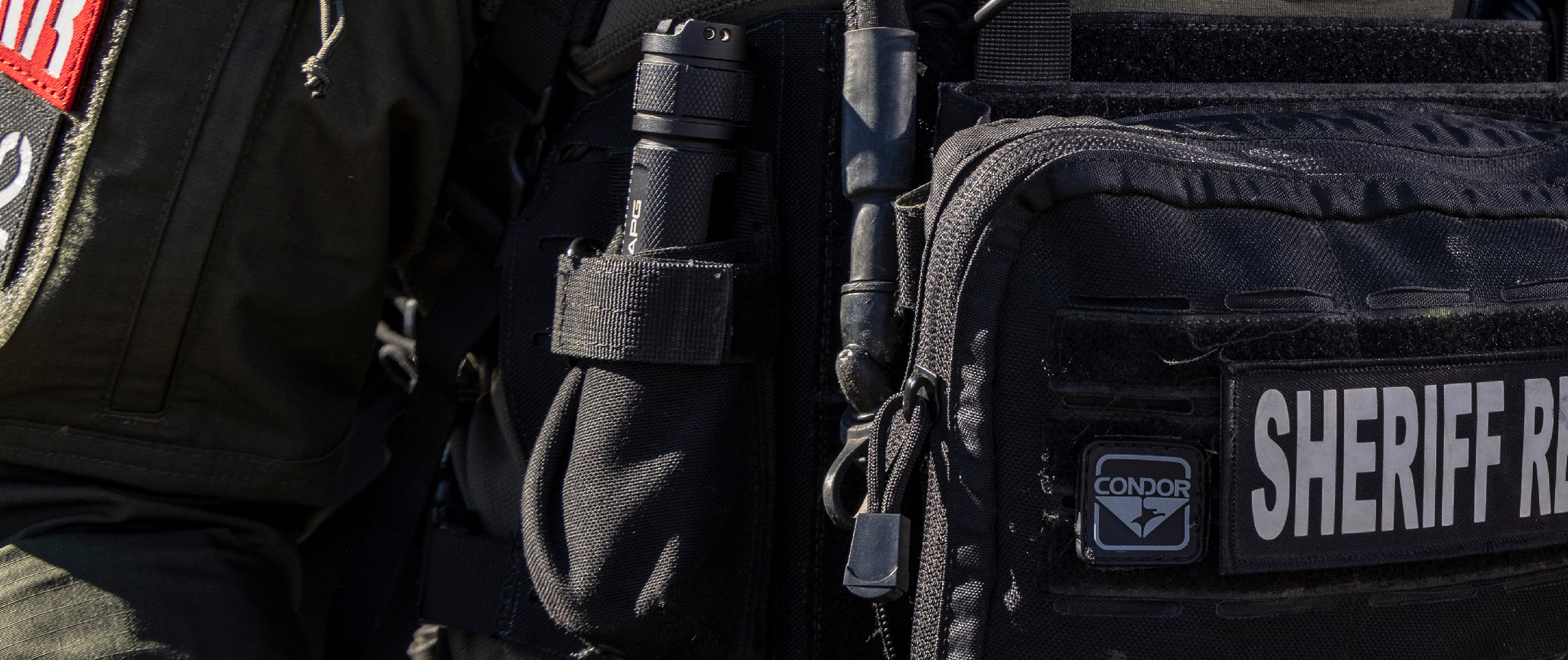 Flashlight pouch mounted on a chest rig harness and stowaway combo
