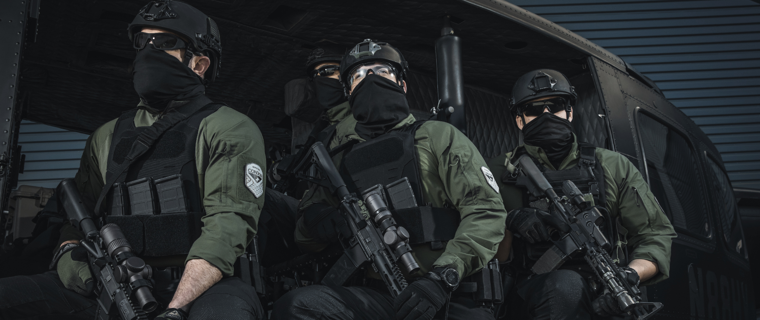 Image of 3 security professionals on a helicopter wearing specter plate carriers