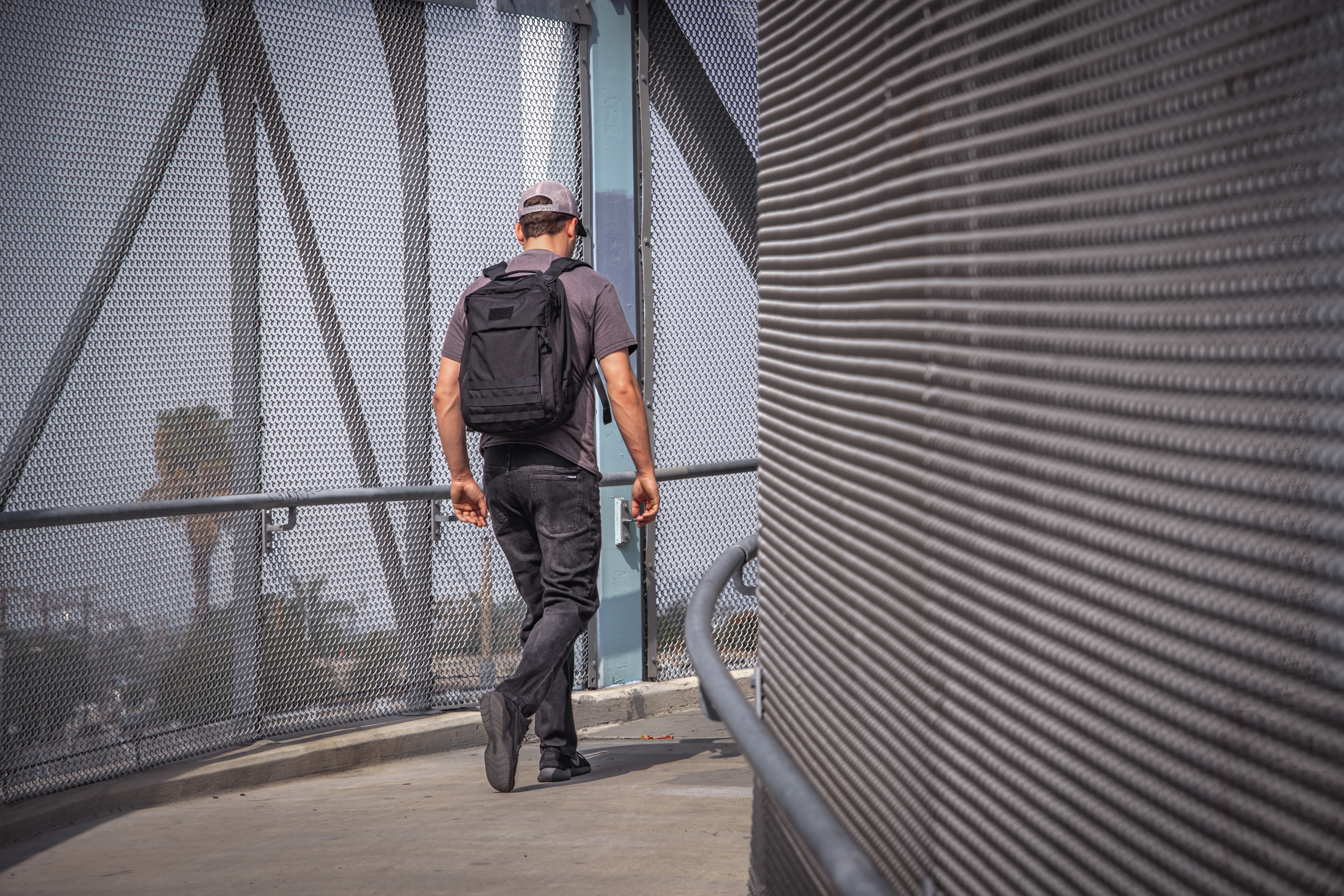 Image of a person walking on an overpass while wearing the prime pack 21l