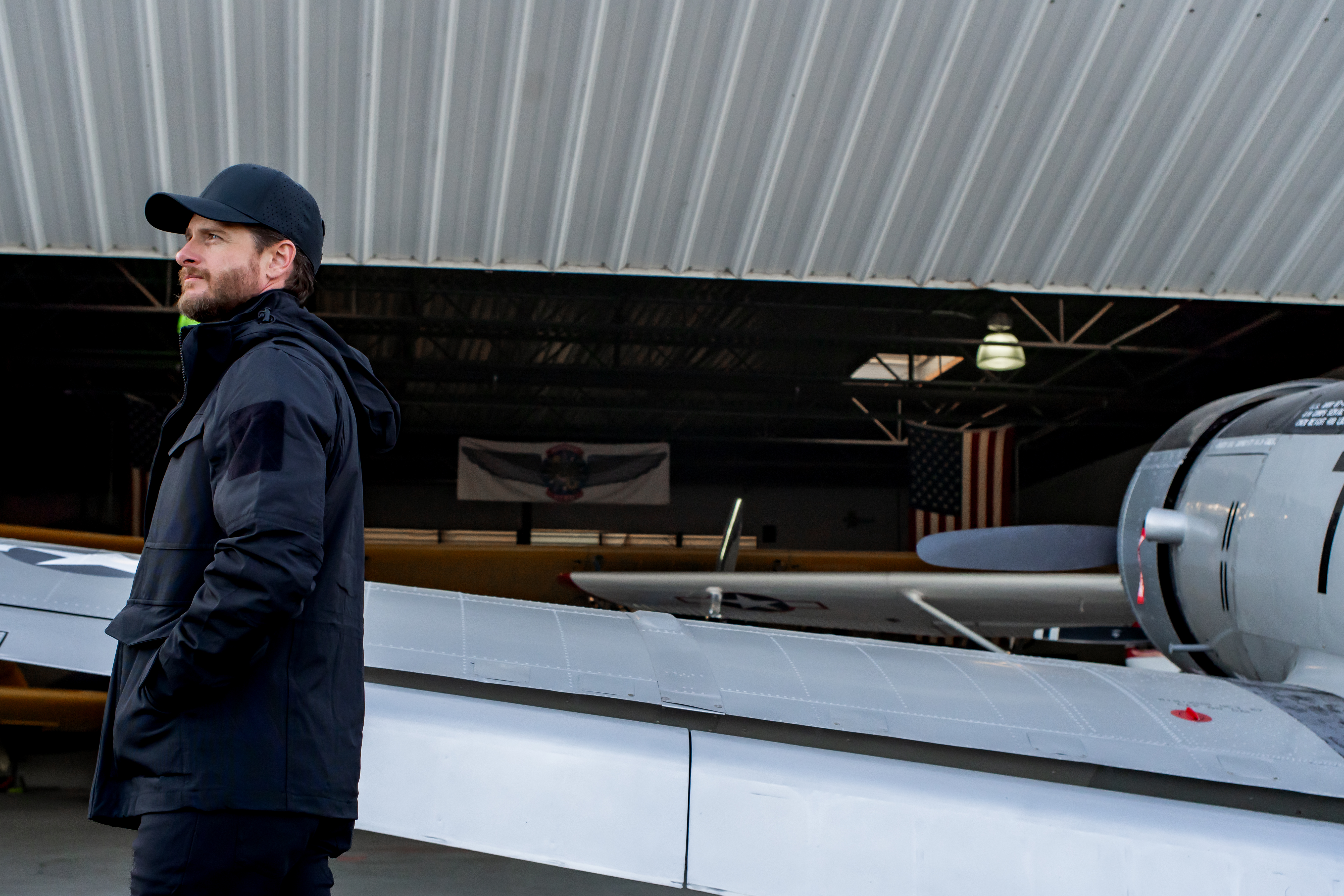 Image of a person standing next to a plane wearing the waterproof parka